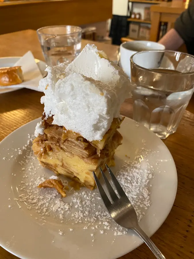 Ein Stück Scheiterhaufen mit Baiserhaube und Staubzucker