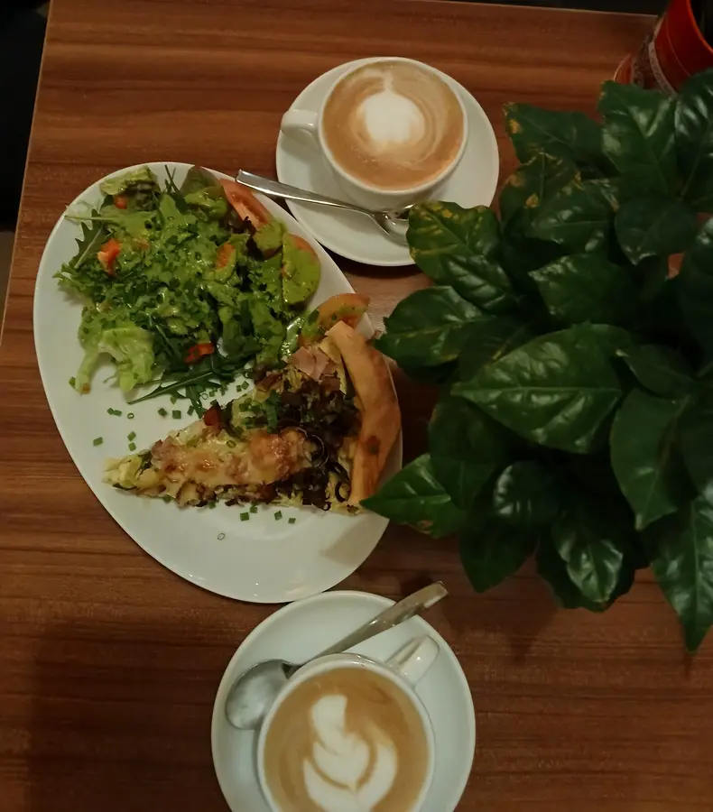 Quiche mit grünem Salat und zwei Cappuccino von oben fotografiert